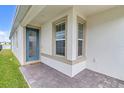 Inviting front entrance featuring a stylish blue door and brick paved porch at 1872 Summer Serenity Dr, Kissimmee, FL 34744