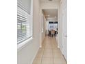 Bright hallway with natural light, leading into a dining area and offering a glimpse of the backyard at 1872 Summer Serenity Dr, Kissimmee, FL 34744