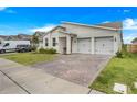 A cozy single-story home with an attached two-car garage and brick-paved driveway at 18863 Rawson St, Orlando, FL 32827