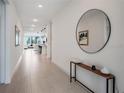 Bright hallway features neutral colors, tile flooring, console table and decor at 18863 Rawson St, Orlando, FL 32827