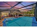 Relaxing screened-in pool area with a hot tub, lounge chairs, and ample seating for entertaining guests at 219 Breezy Oaks Ct, Davenport, FL 33896