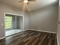 Bright bedroom featuring sliding glass doors, neutral paint, and hard surface flooring at 220 E Desoto St # C, Clermont, FL 34711