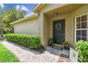 The front door, adorned with a wreath, invites you into this meticulously landscaped home at 223 Bell Tower W Xing, Poinciana, FL 34759