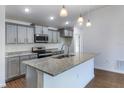 Modern kitchen with granite countertops, stainless steel appliances, and stylish gray cabinets at 250 Beckenham Dr, Kissimmee, FL 34758