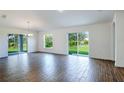 Bright living room with wood-style floors, sliding glass doors to the backyard, and a chandelier at 250 Beckenham Dr, Kissimmee, FL 34758