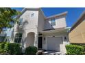 Two-story stucco home featuring a one-car garage and classic architecture at 2952 Beach Palm Ave, Kissimmee, FL 34747