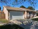 A close up of an attached garage and neutral colored exterior of a charming home at 308 S Shadow Bay Dr, Orlando, FL 32825