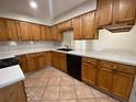 Kitchen features wood cabinets, black appliances, and tile countertops with a tile backsplash at 308 S Shadow Bay Dr, Orlando, FL 32825