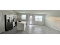 A bright, modern kitchen features stainless steel appliances, white cabinets, and a center island at 312 Nine Iron Dr, Davenport, FL 33896