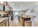 Bright kitchen featuring granite countertops, stainless steel appliances, and an eat-in island at 314 Annabelle Way, Davenport, FL 33837