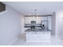 Bright kitchen features an island, white cabinets, stainless steel appliances, and modern lighting at 3470 Beau Rd, Kissimmee, FL 34746