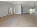 Spacious living room with neutral carpet and paint leading to a screened back porch at 36 Inconnu Dr, Poinciana, FL 34759