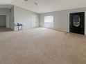 Expansive living room featuring plush tan carpeting, natural light and modern interior design at 36 Inconnu Dr, Poinciana, FL 34759