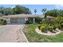 Well-maintained home featuring a two-car garage and lush front yard landscaping at 5137 Links Ln, Leesburg, FL 34748