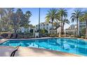 Inviting community pool surrounded by lush palm trees, providing a relaxing resort-style atmosphere at 7683 Heritage Crossing Way # 202, Reunion, FL 34747