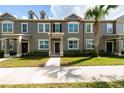 Charming townhome with manicured landscaping and a neutral color palette, complemented by a mature palm tree at 8612 Brookvale Dr, Windermere, FL 34786