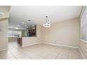 Bright open-concept living and dining area featuring neutral walls, tile flooring, and a modern light fixture at 8612 Brookvale Dr, Windermere, FL 34786