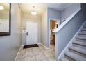 Welcoming foyer with tile floors, featuring a staircase and a view of the downstairs bathroom at 8971 Candy Palm Rd, Kissimmee, FL 34747