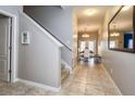 Light-filled hallway with tile flooring, leading to a dining area with a staircase on the left at 8971 Candy Palm Rd, Kissimmee, FL 34747