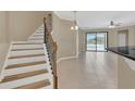 Bright foyer with staircase showcasing tile flooring with backyard views from the sliding doors at 2784 Corbel Loop, Kissimmee, FL 34746