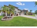 Beautifully landscaped front yard with palm trees complements this stunning three-car garage home at 2784 Corbel Loop, Kissimmee, FL 34746
