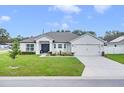 Charming one-story home with a 2-car garage, manicured lawn, and landscaped front yard at 1083 Snively Cir, Lake Hamilton, FL 33851