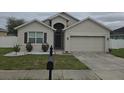 Charming single-story home with neutral stucco, a two-car garage, and well-maintained landscaping at 130 Highland Meadows St, Davenport, FL 33837