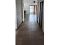 Spacious hallway featuring neutral tile flooring that transitions into the living area with natural light streaming through the glass doors at 130 Highland Meadows St, Davenport, FL 33837