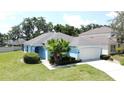 Beautiful single-story home featuring mature landscaping and a two-car garage at 1301 Rebecca Dr, Haines City, FL 33844