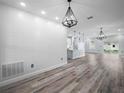 Bright open-concept living room featuring modern light fixtures, sleek flooring, and a stylish textured wall at 145 Willow Dr, Poinciana, FL 34759