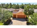 A sunny aerial view of the home shows a charming home featuring a three-car garage at 1825 Pelican Hill Way, Kissimmee, FL 34759
