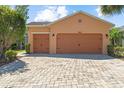 Charming home featuring a three-car garage and a meticulously paved driveway, offering curb appeal at 1825 Pelican Hill Way, Kissimmee, FL 34759