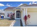 Inviting front entrance with a screen door, pathway, and colorful plants around the exterior at 2049 Shannon Lakes Blvd, Kissimmee, FL 34743