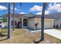Charming single-story home featuring a two-car garage and colorful landscaping at 2049 Shannon Lakes Blvd, Kissimmee, FL 34743