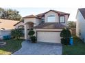 Attractive two-story home featuring a two-car garage, a paved driveway, and lush lawn at 2110 Korat Ln, Maitland, FL 32751