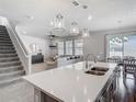 Open-concept kitchen with stainless steel sink, adjacent living room and staircase at 2279 Raven Ridge Road, Minneola, FL 34715