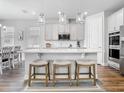 Bright kitchen featuring an island with barstool seating, stainless steel appliances, and white cabinets at 2279 Raven Ridge Road, Minneola, FL 34715