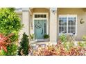 Welcoming front entrance with a stylish door, decorative wreath and manicured landscaping at 3191 Marshfield Preserve Way, Kissimmee, FL 34746