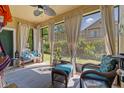 Cozy screened-in sunroom with wicker furniture, flowing curtains, and serene views of the landscaped backyard at 3535 Clay Brick Rd, Harmony, FL 34773