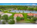 Aerial view of a single Gathering home with a terra cotta roof, a lake view, and mature trees at 4117 Navigator Way, Kissimmee, FL 34746
