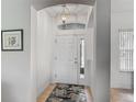 A bright and airy foyer with a white front door and a decorative overhead light fixture at 4117 Navigator Way, Kissimmee, FL 34746
