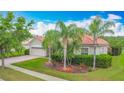 Single Gathering home featuring a terra cotta roof, lush landscaping, and a brick driveway at 4117 Navigator Way, Kissimmee, FL 34746