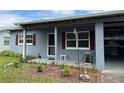 Close up of charming one-story home with covered entry and red shutters at 921 Louisiana Ave, St Cloud, FL 34769