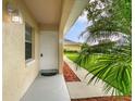 Inviting entryway featuring a white front door, well-manicured landscaping, and a charming outdoor light fixture at 12513 Indiana Woods Ln, Orlando, FL 32824