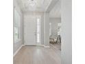 Bright foyer features elegant chandelier, wood floors, and views into the living area at 12755 Westside Village Loop, Windermere, FL 34786