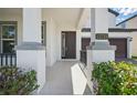 Inviting front entryway with decorative columns and wrought iron railing leading to a stylish door at 12755 Westside Village Loop, Windermere, FL 34786