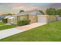 Exterior showcasing a well-manicured lawn and an attached garage with a concrete driveway at 1422 Missouri Ave, St Cloud, FL 34769