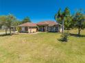 Well-maintained single-story home with a lush green lawn, complemented by mature landscaping and blue skies at 1941 Mathis Rd, St Cloud, FL 34771