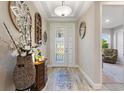Welcoming entryway with a decorative glass front door, neutral walls, and wood-look tile flooring at 1948 Molise Dr, Kissimmee, FL 34759