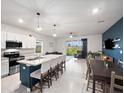 Open-concept floor plan with modern kitchen flowing into the living and dining areas at 208 Feltrim Reserve Blvd, Davenport, FL 33837
